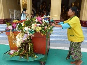 Woman with leftover flowers at pagoda