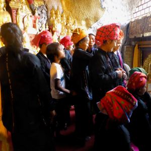 Shan women waiting to put gold leaf on Buddha figures