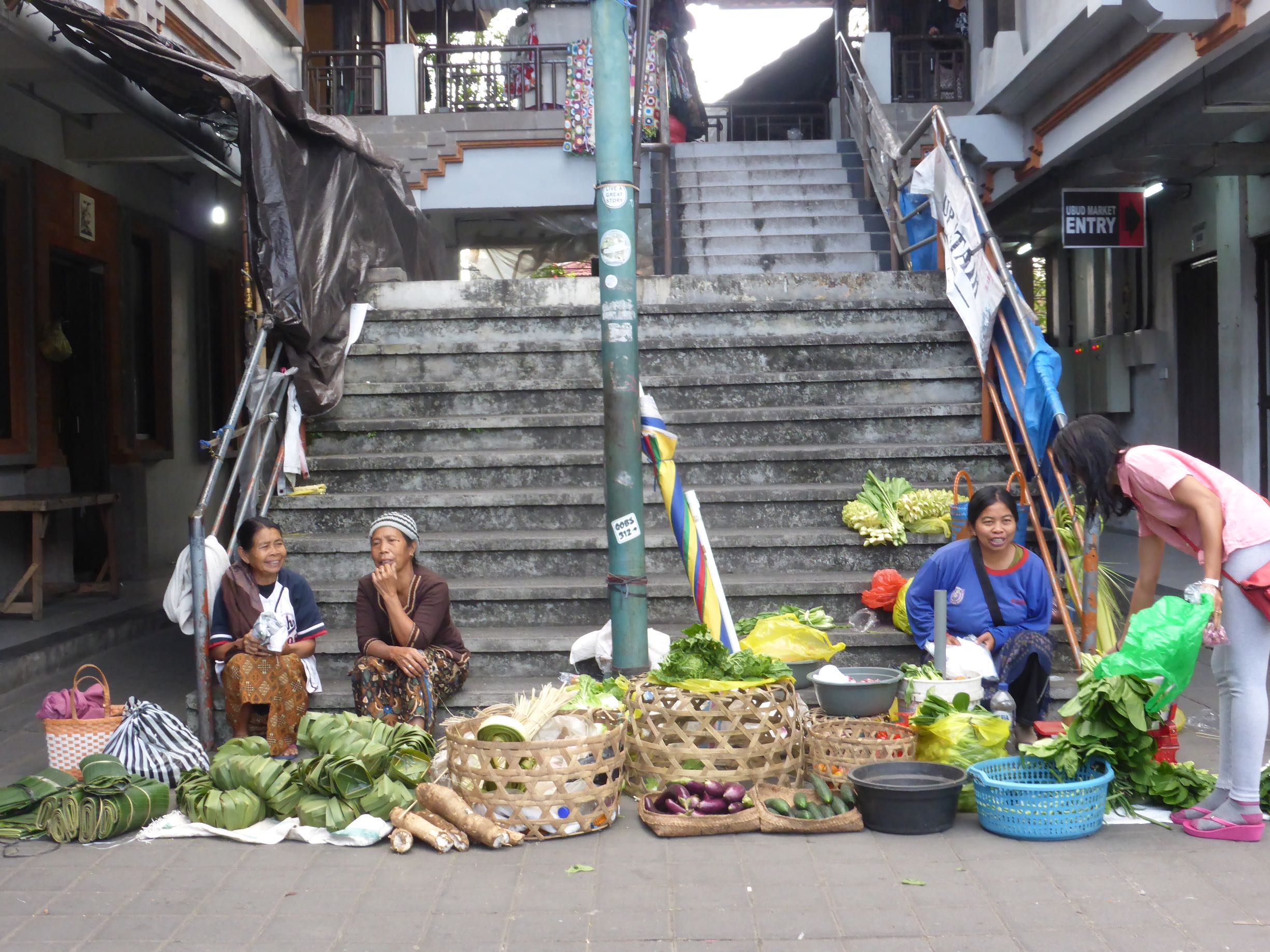 sellers sitting at bottom of concrete stairs
