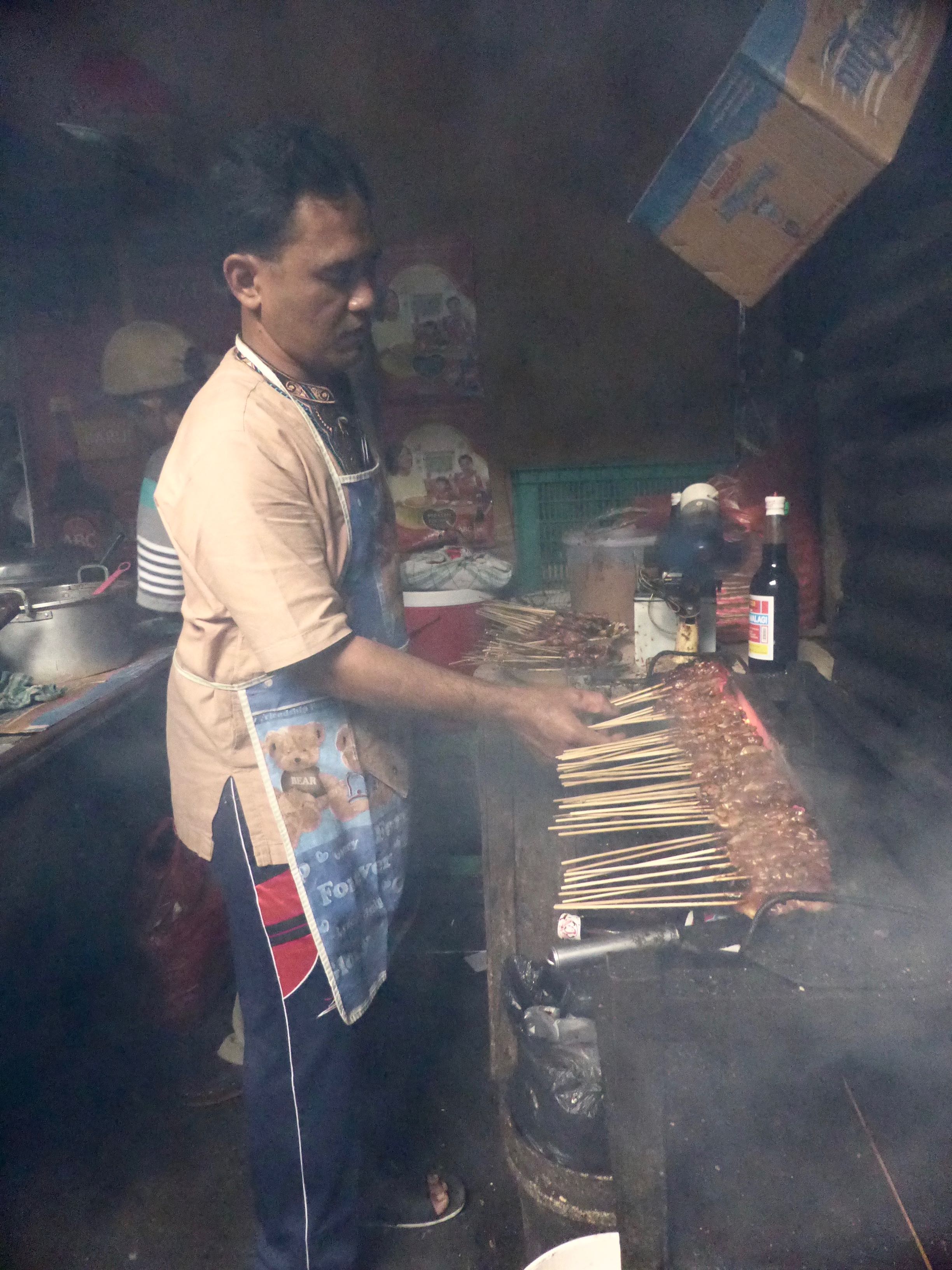 man grilling with smoke