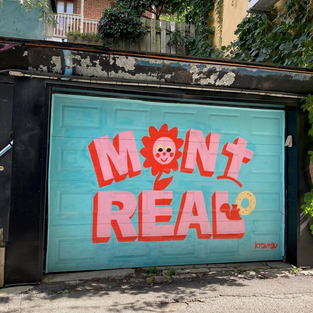 garage door with painted turquoise and pink letters spelling out "Montréal"